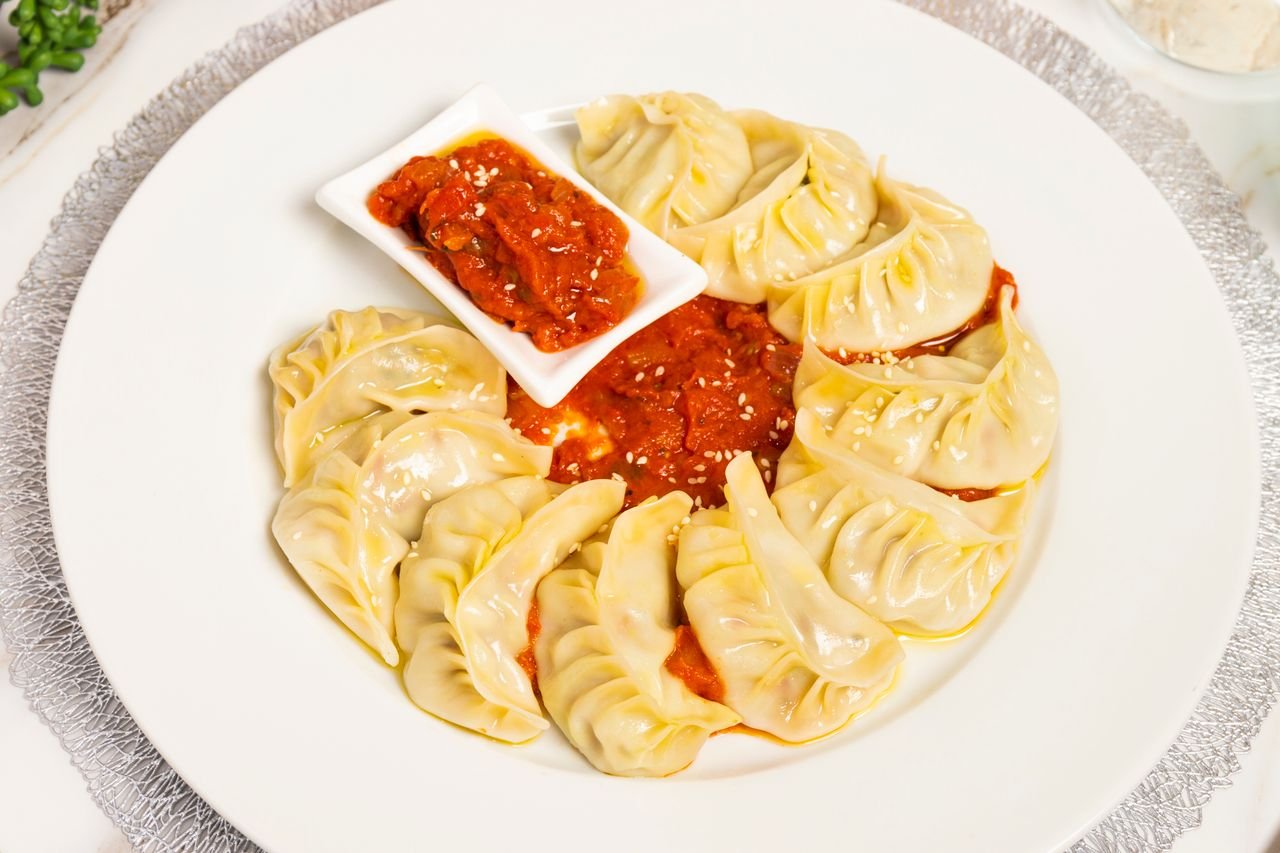 Tasty dumplings served with a vibrant spicy sauce, perfect for gourmet lovers.